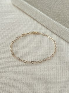 "Hearts are melting for this dainty yet durable mini heart chain bracelet! 💛 This unique chain is sensitive skin and water safe, and is made to live your life in! Wear this minimal piece to brunch, or on a date... this simple heart chain looks lovely anywhere you take it! Details: * 3.5mm 14K Gold Filled heart chain * Dainty 14K Gold Filled spring clasp * 14/20 gf stamp for authenticity * Choose your length (each bracelet comes with a .5\" extender chain for adjustable sizing.) * Made with all Simple Chain Bracelet, Dainty Heart Bracelet With Delicate Chain For Valentine's Day, Dainty Delicate Chain Bracelets For Valentine's Day, Adjustable Dainty Chain Bracelet With Heart Charm, Dainty Delicate Chain Bracelet For Valentine's Day, Dainty Bracelets With Adjustable Chain For Valentine's Day, Dainty Adjustable Charm Bracelet For Valentine's Day, Dainty Adjustable Chain Bracelet For Valentine's Day, Adjustable Heart-shaped Delicate Chain Bracelet