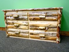 a wooden dresser sitting on top of a carpeted floor next to a green wall