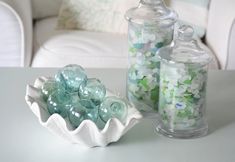 a white table topped with vases filled with glass pebbles