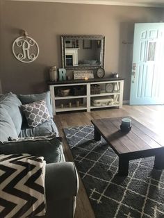 a living room filled with furniture and a mirror on the wall over a coffee table