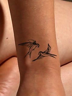 a woman's arm with two birds tattoo on the left side of her leg