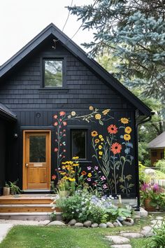 a black house with flowers painted on the side