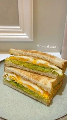 two sandwiches are stacked on a plate