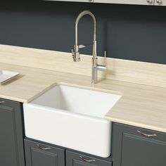 a kitchen sink sitting under a faucet next to a counter top with dishes on it