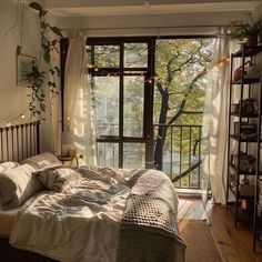 a bed sitting next to a window in a room with lots of plants on the wall