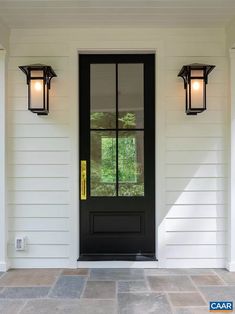 a black front door with two lights on it