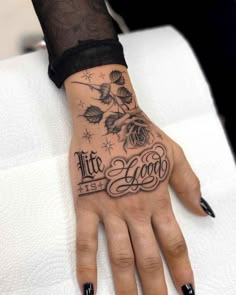 a woman's hand with tattoos on it and the words life is good written in cursive letters