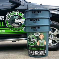 two trash cans sitting next to each other in front of a black truck with the words brute on it