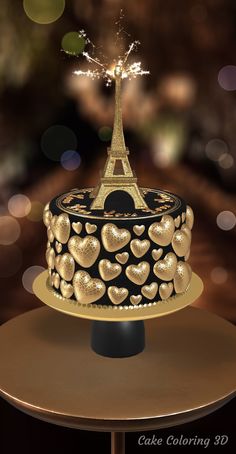 a cake decorated with gold hearts and the eiffel tower is lit up in the background