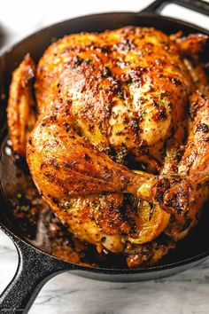 a cooked chicken in a skillet on a table