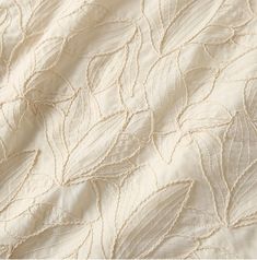 an image of a white quilted material with leaves on the top and bottom half