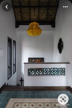 a room with tile flooring and a yellow light hanging from the ceiling above it