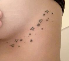 a woman's stomach with stars and hearts tattooed on her side, showing the word love written in cursive writing