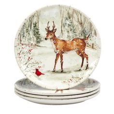 three plates decorated with deer in the snow and red cardinal bird on each plate,