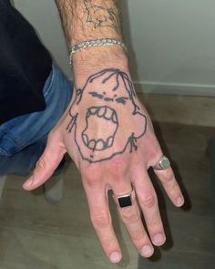 a man's hand with a drawing of a gorilla on it and his ring