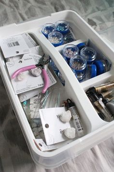 an organized drawer on a bed filled with makeup and personal care items, including toothbrushes