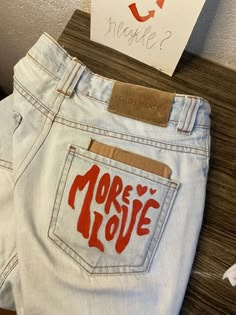 a pair of jeans with the words more love painted on them