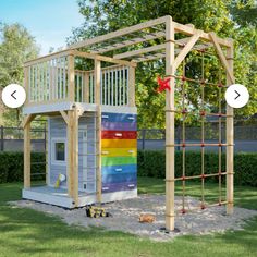 an outdoor play structure with climbing bars and ladders on the side, in front of a tree