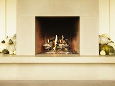 a fire place with pumpkins and gourds on the mantle