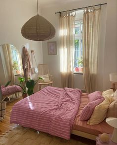 a bed room with a neatly made bed next to a window and a mirror on the wall