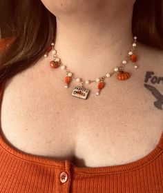 a close up of a woman wearing a necklace with beads and charms on her chest