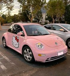 a pink car with hello kitty painted on it's side in a parking lot