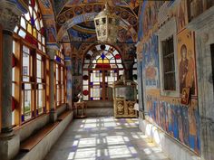 an old building with stained glass windows and paintings on the walls