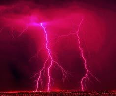 two lightning strikes in the sky over a field