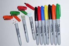 several pens and markers are lined up in a row