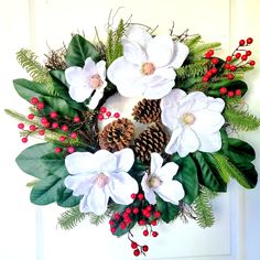 a wreath with white flowers and pine cones