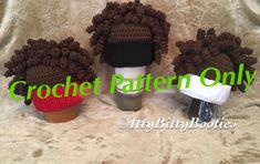 three crocheted hats with pom poms are on top of a white blanket