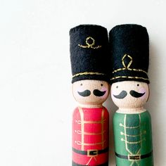 two wooden nutcrackers with black hats and tails