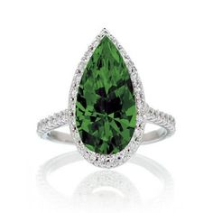 a pear shaped green diamond ring with diamonds around the band and an oval cut stone in the center