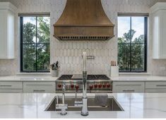 a kitchen with an oven, sink and stove top in it's center island