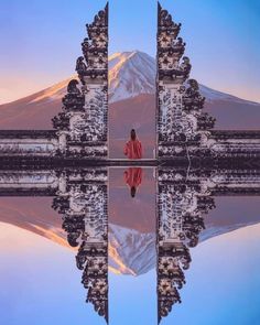 a person standing in front of a mountain with a reflection on the water's surface