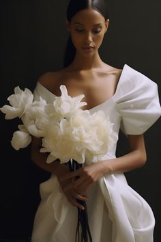 a woman in a white dress holding a bouquet of flowers