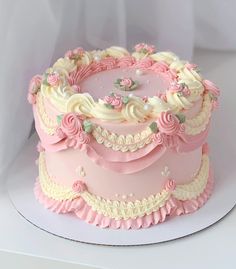 a pink and white cake with flowers on it