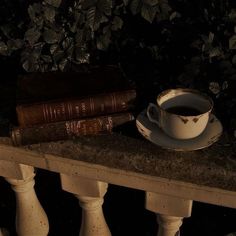 a cup of coffee sitting on top of a table next to two books