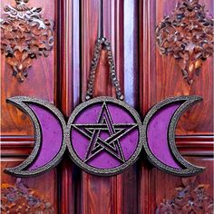 the door is decorated with three phases of the moon, and one has a pentagramil on it