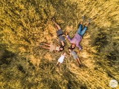 three people laying on the ground with their arms around each other in an aerial view