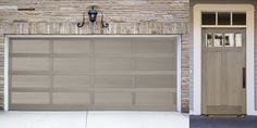 two garage doors are shown side by side in front of a brick wall and door