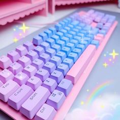 a pink and blue keyboard sitting on top of a desk