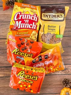 some snacks are sitting on a wooden table next to pine cones and candy bar wrappers