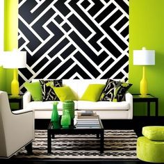 a living room filled with furniture and green accents on the walls, along with black and white wallpaper