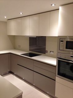 a modern kitchen with white cabinets and stainless steel appliance, including an oven