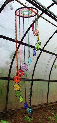 the inside of a greenhouse with many colorful objects hanging from it