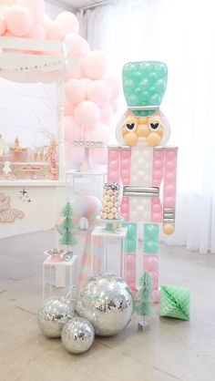 an assortment of balloons and decorations in a room with pink, green and white decor