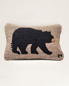 a black bear is on the side of a pillow that's made out of burlap