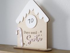 a wooden house with the number ten days until it's snowing on top