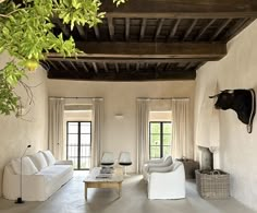 a living room with white couches and chairs